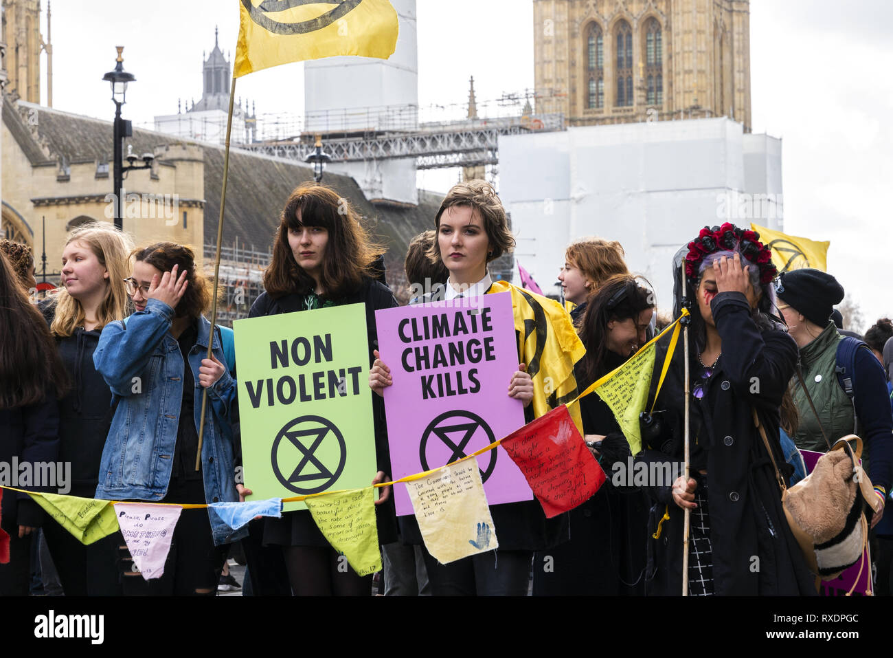 London, UK. 9th Mar, 2019. Extinction Rebellion Rally a demonstration at Downing Street. Women holding banners 'Non-Violent' and 'Climate Change Kills'. Credit: AndKa/Alamy Live News Stock Photo