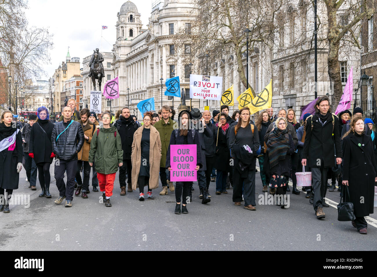 London, UK. 9th Mar, 2019. Extinction Rebellion Rally a demonstration at Downing Street. Woman holding banner 'Our Blood Our Future'. Credit: AndKa/Alamy Live News Stock Photo