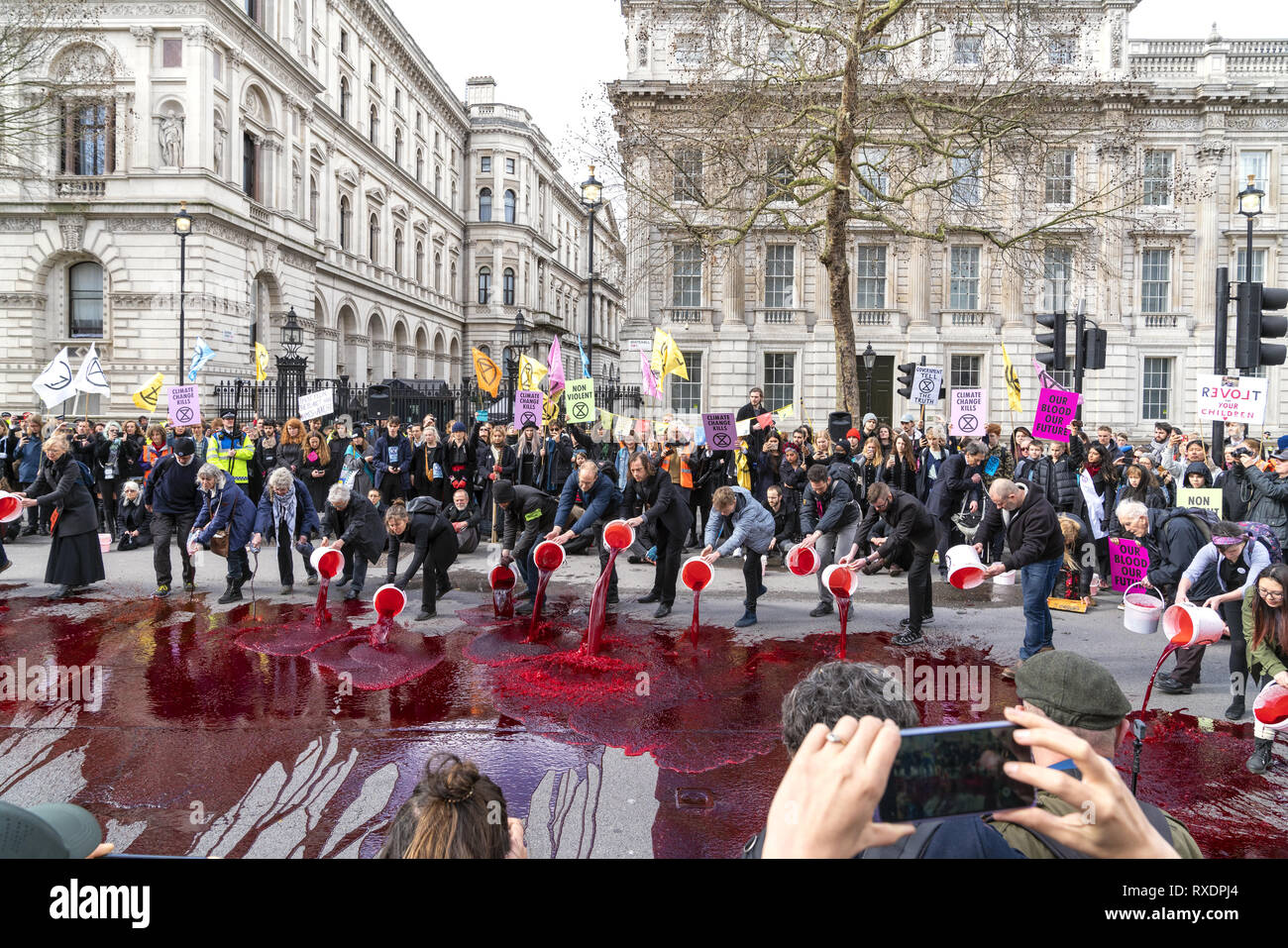 London, UK. 9th Mar, 2019. Extinction Rebellion Rally a demonstration at Downing Street. Protestors create a sea of ‘blood' at Downing St to call alarm on climate and ecological emergency. Credit: AndKa/Alamy Live News Stock Photo