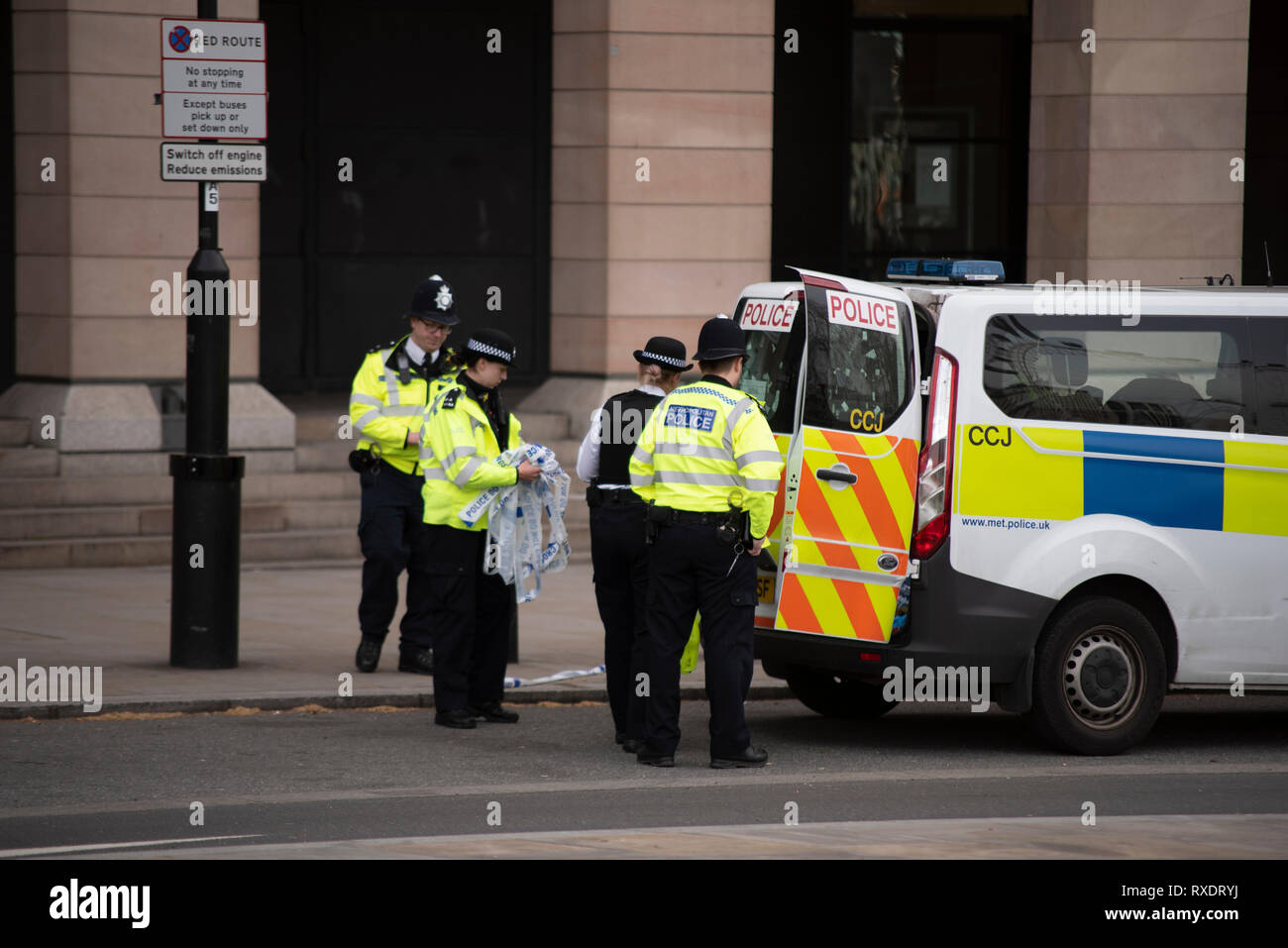 A suspicious car parked outside New Scotland Yard police headquarters on Victoria Embankment, Westminster, London, UK caused the police to lockdown and clear the the area around it and Westminster Bridge, including stopping river traffic on the Thames. Police broke the rear screen of the car to gain entry. Stock Photo