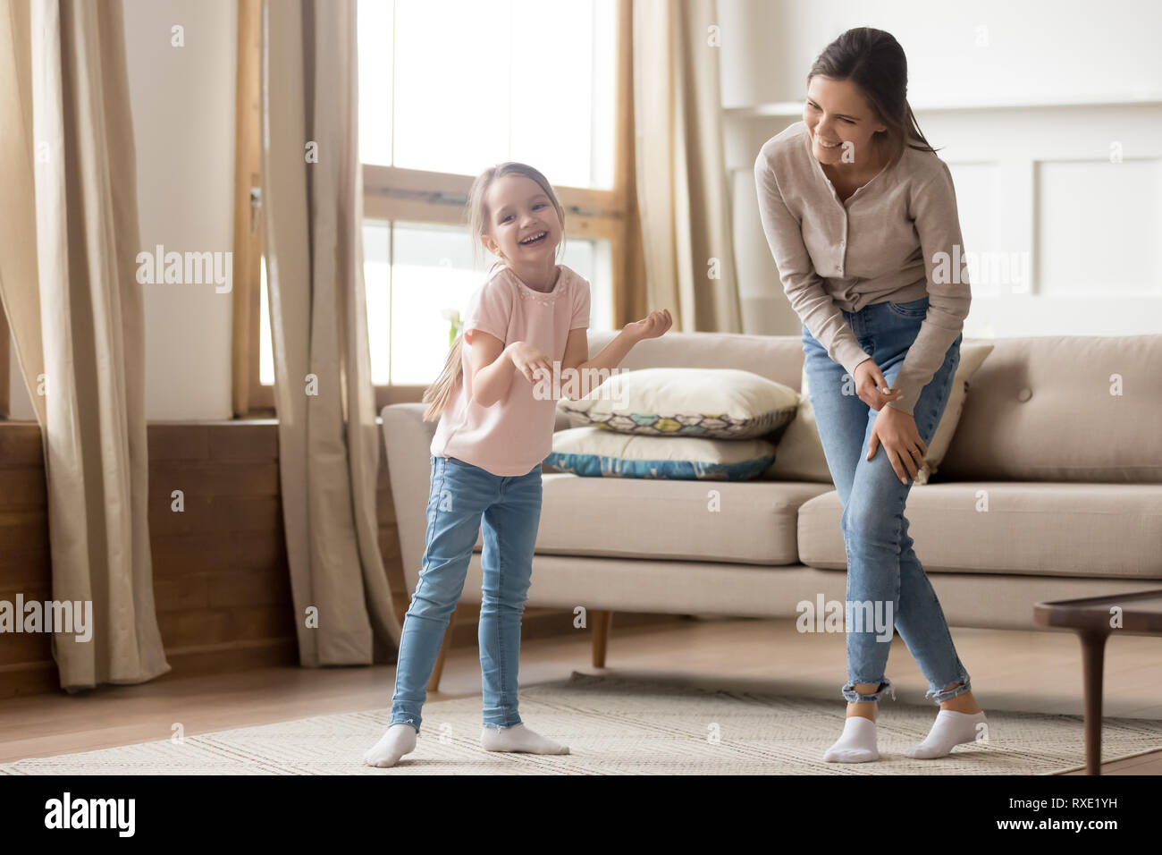 Happy playful cute child daughter laughing dancing with young mom Stock Photo