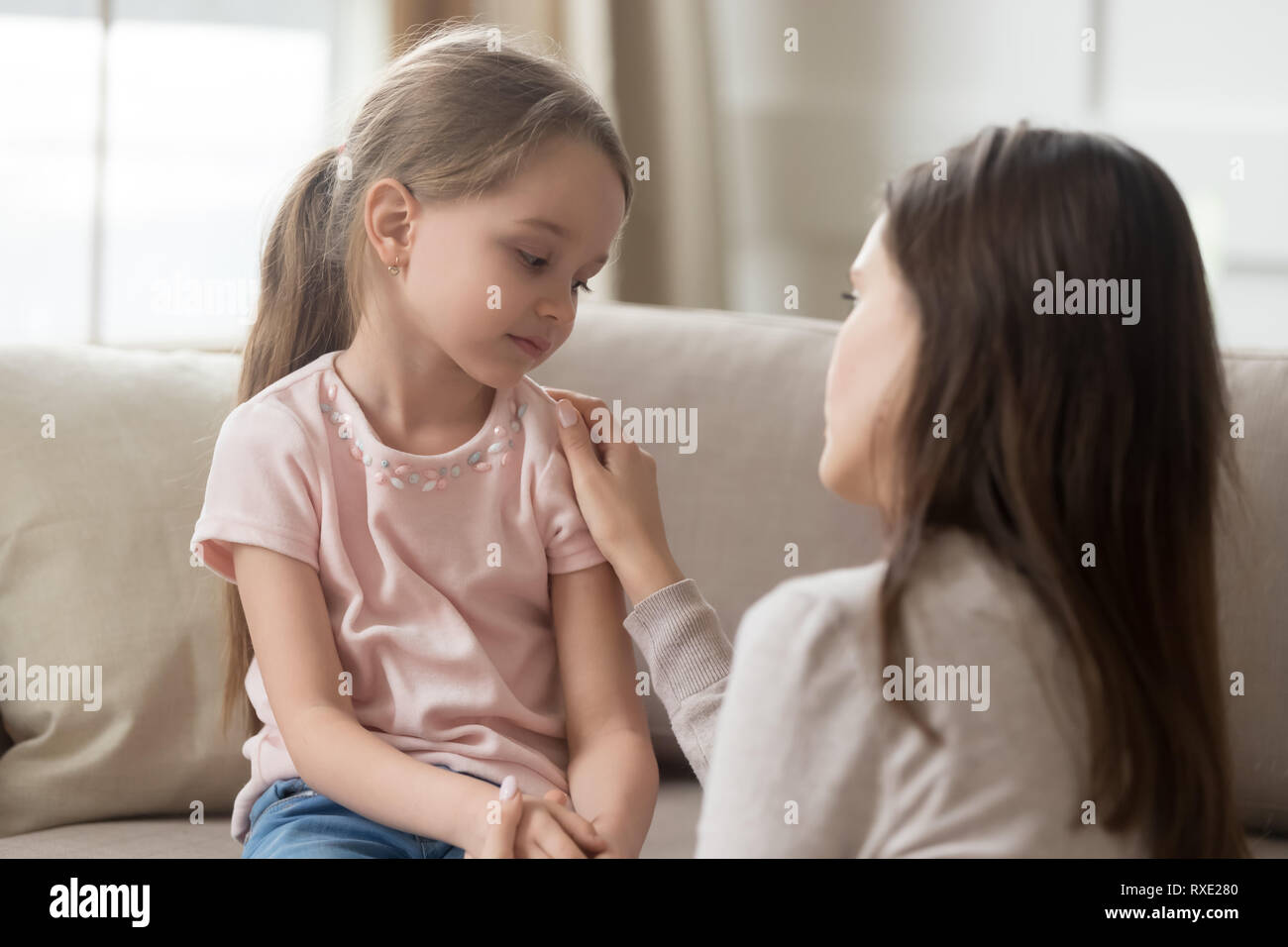 Loving mom talking to upset little child girl giving support Stock Photo