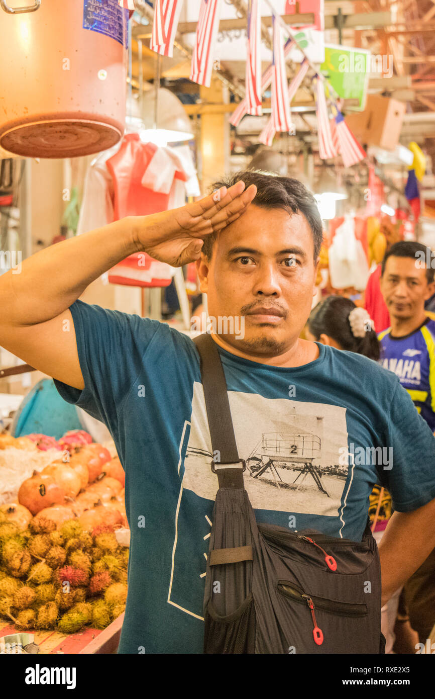 local Asian market trader man salutes in Chow Kit dry market Kuala Lumpur Malaysia Stock Photo