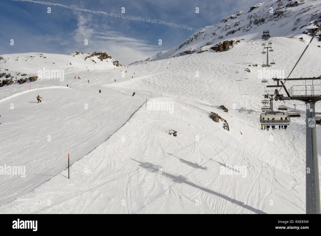 Engelberg, Switzerland - 3 March 2019: People skiing and going up the mountain by chairlift at Engelberg on the Swiss alps Stock Photo