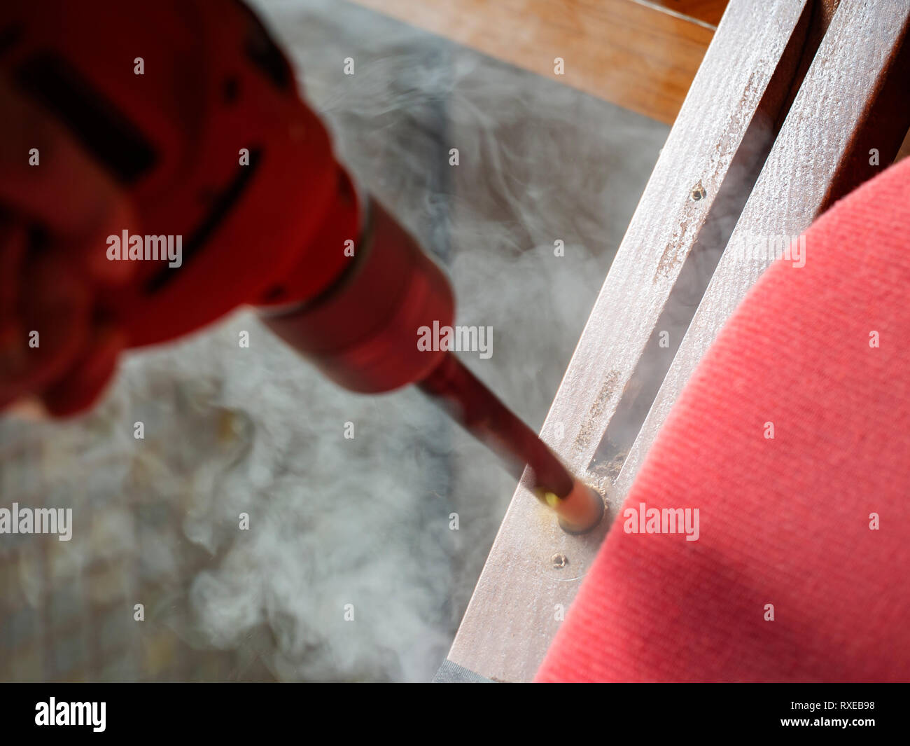 Blunt drill bit, smoke while making hole in wood. DIY issue. Stock Photo