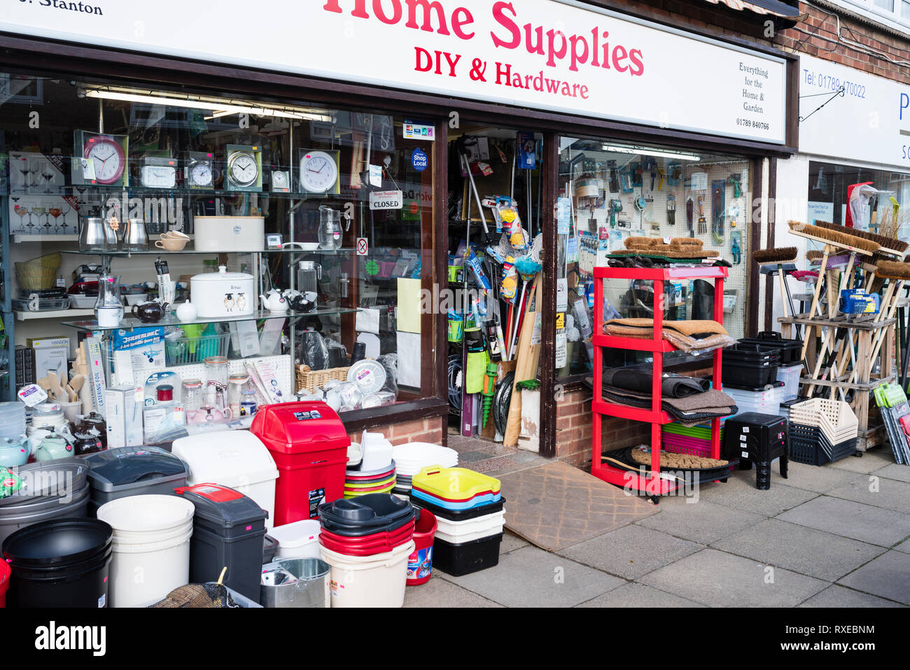 English village life - a hardware store with displays on the street in front. Stock Photo