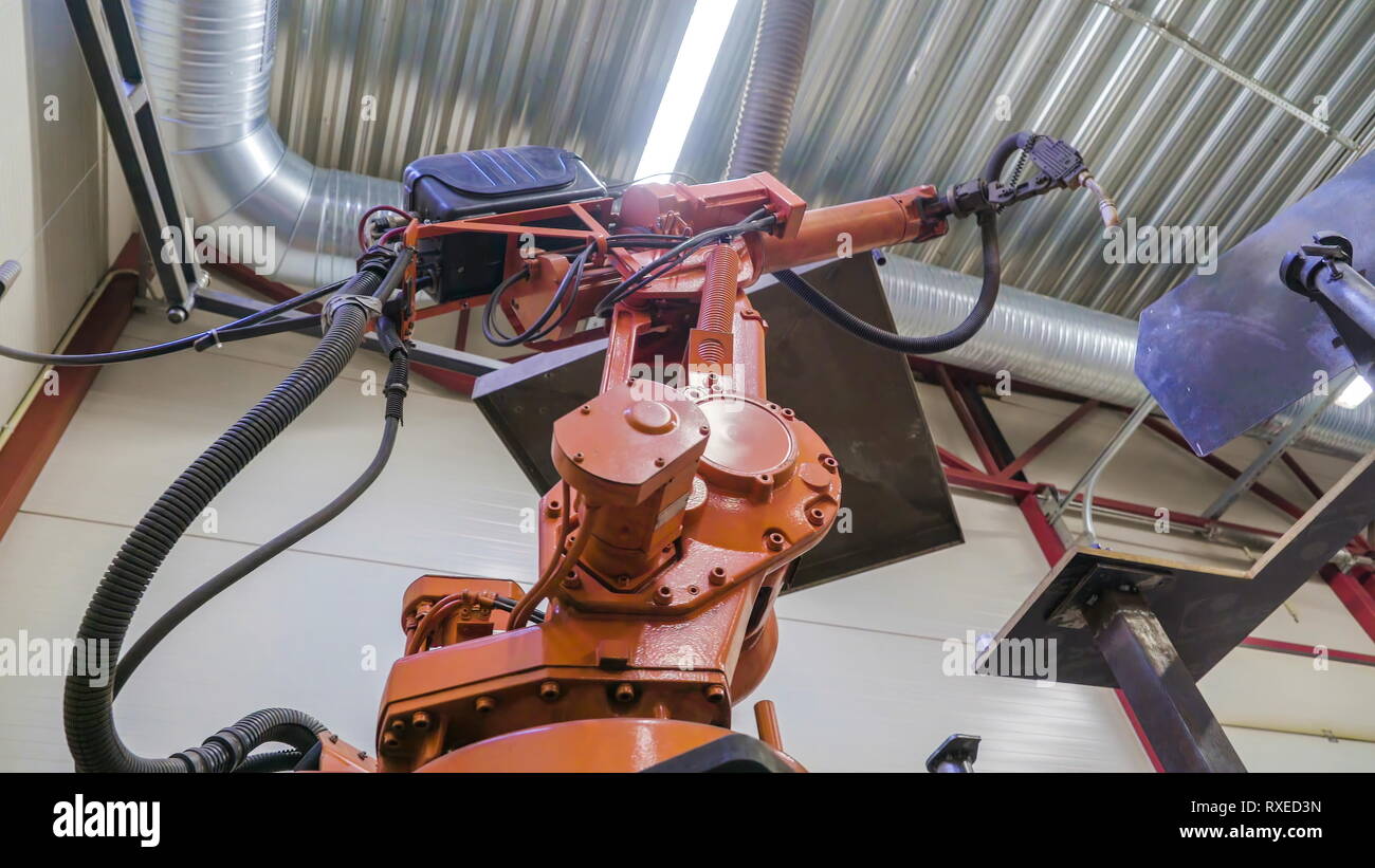 The welding robot inside the factory it is a big machine that is doing the welding works Stock Photo