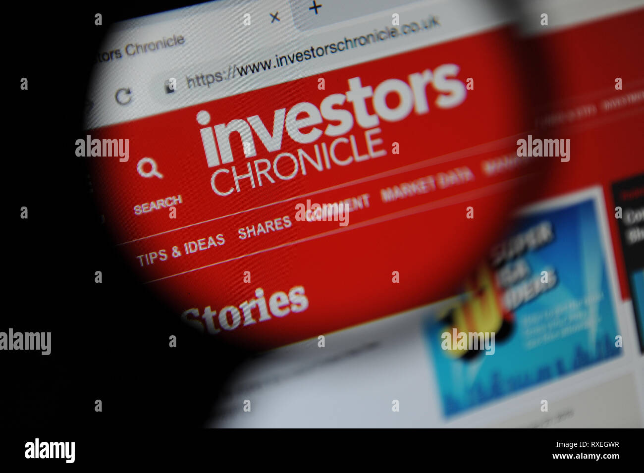 The Investors Chronicle website seen through a magnifying glass Stock Photo