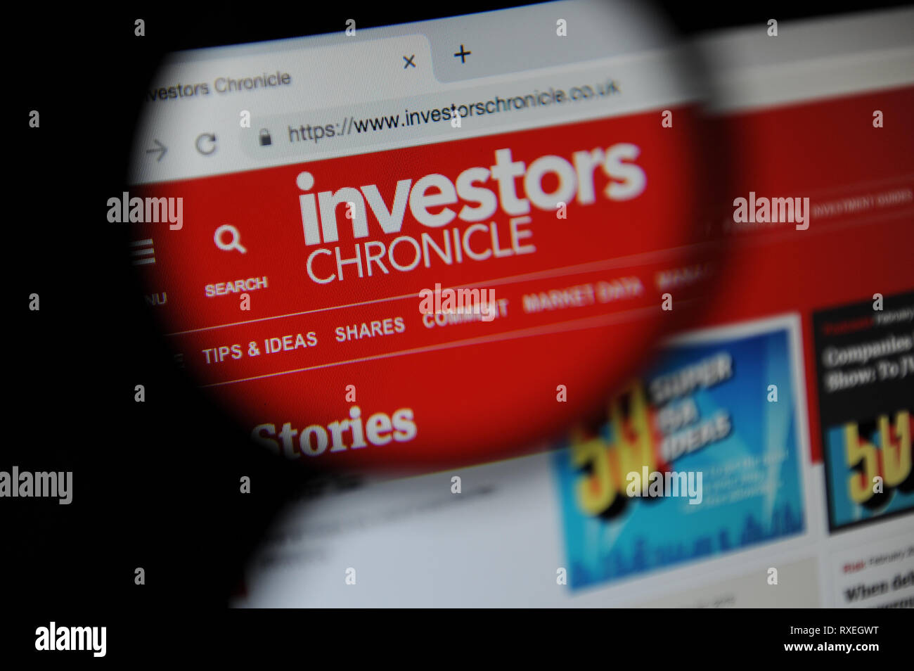 The Investors Chronicle website seen through a magnifying glass Stock Photo