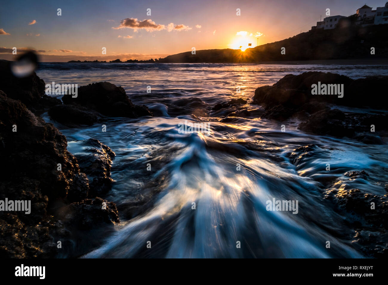 Motion effect with waves and water at the beach with sea and sunrise - vacation and landscape scenery concept - sunlight from sunrise and coloured sky Stock Photo