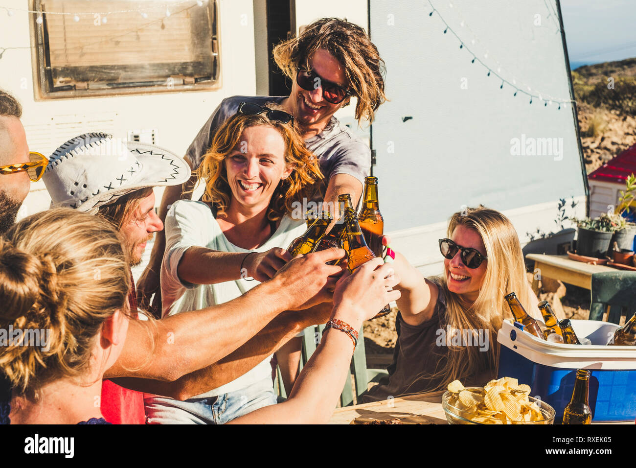 Group of friends young people men and women clinking and toasting having funtogether in outdoor vacation celebration under the sun - have fun concept  Stock Photo