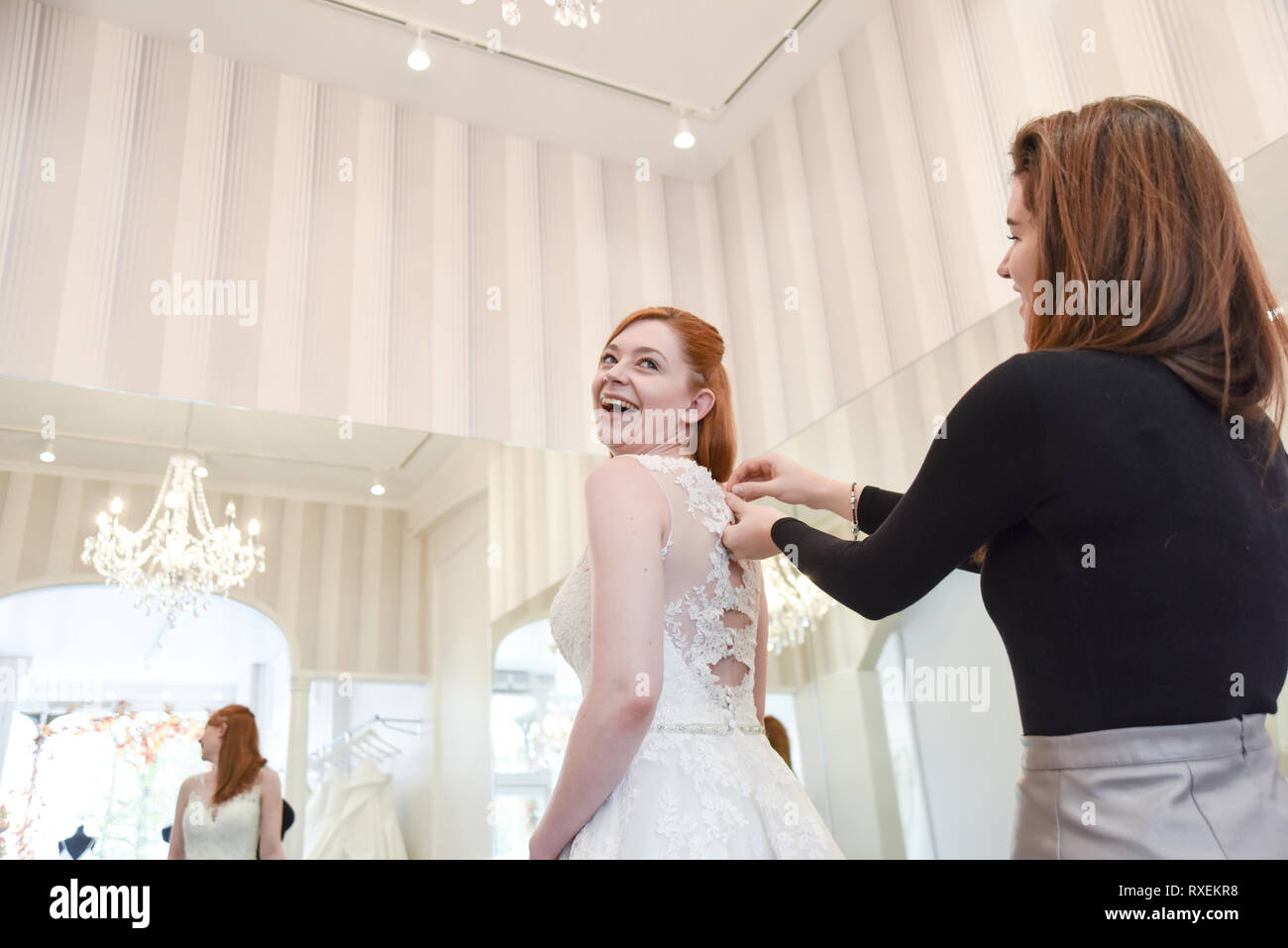 Pretty caucasian girl trying on Wedding dresses in an upmarket Bridal