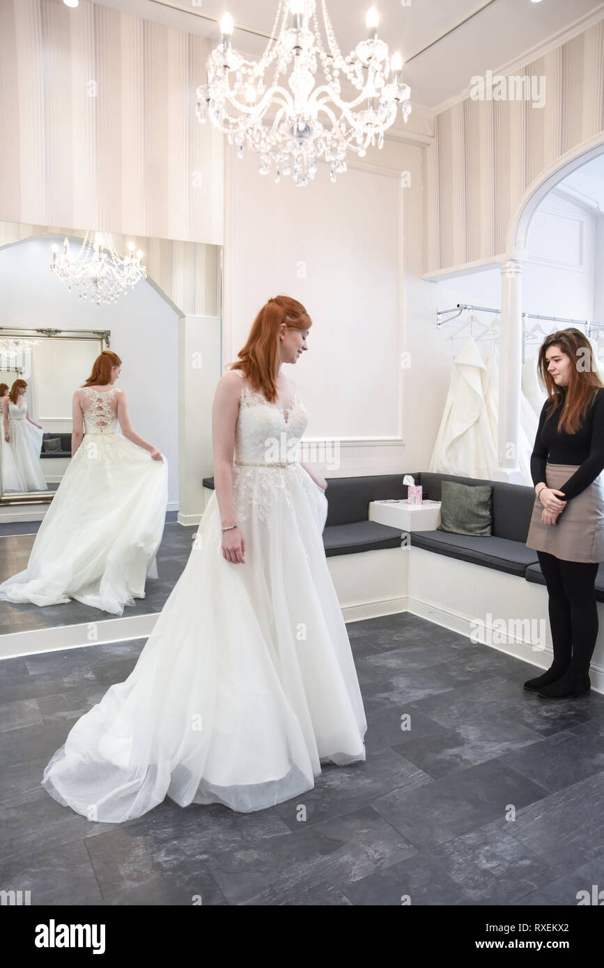 Pretty caucasian girl trying on Wedding dresses in an upmarket Bridal