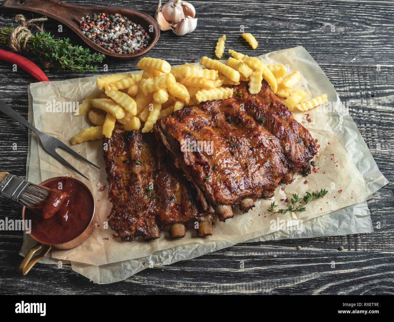 grilled pork ribs with sauce on a cutting board, french fries Stock Photo