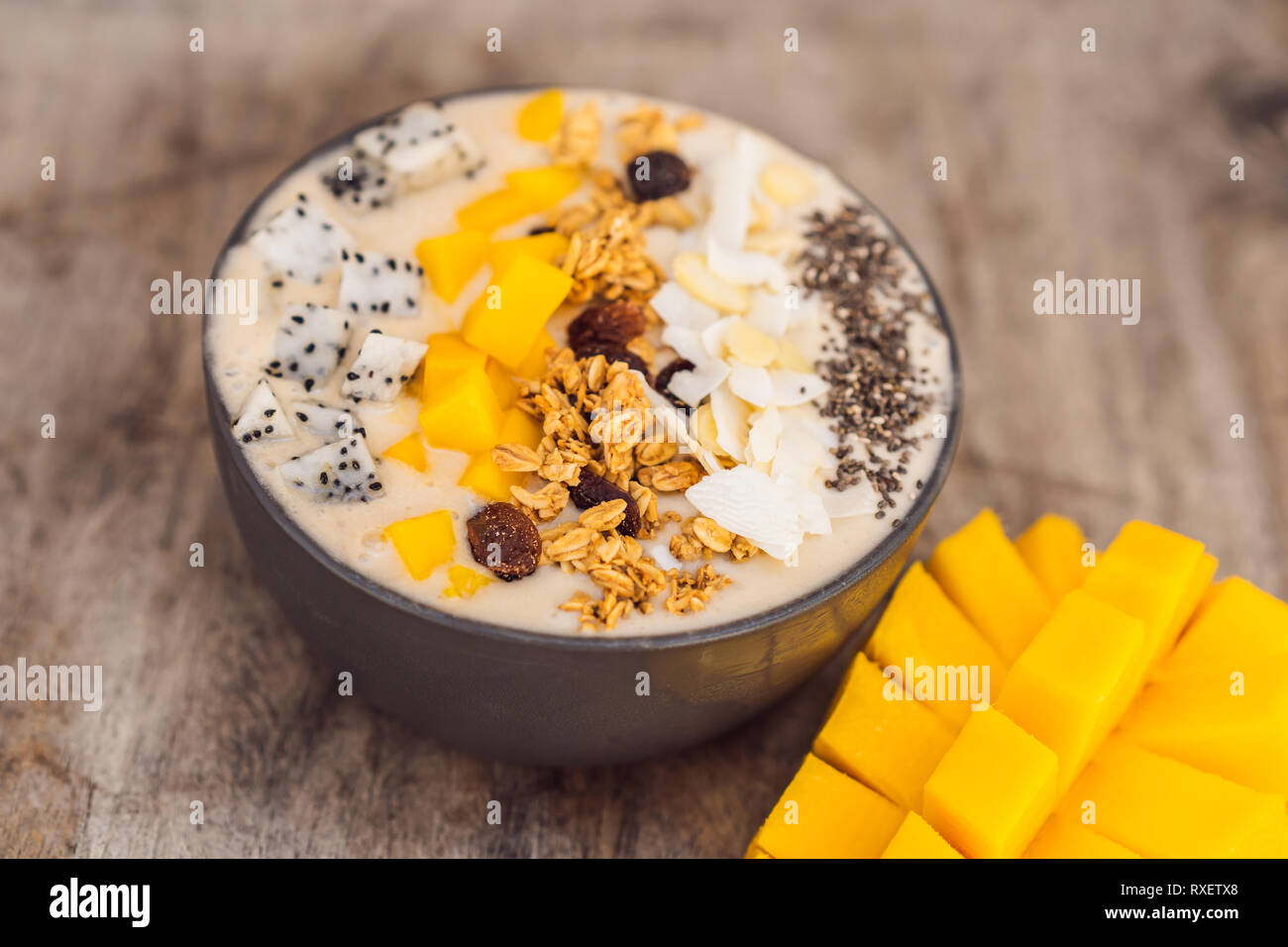 https://c8.alamy.com/comp/RXETX8/smoothie-bowls-made-with-mango-banana-granola-grated-coconut-dragon-fruit-chia-seeds-and-mint-on-wooden-background-concept-fruits-vitamins-RXETX8.jpg