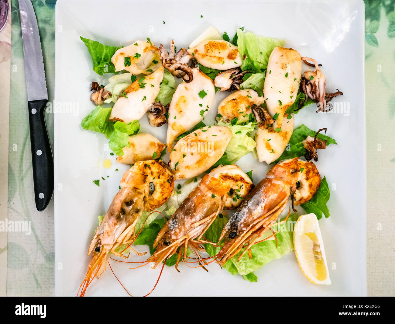 Italian cuisine - top view of fried prawns and squids on white plate in local restaurant in Lombardy Stock Photo