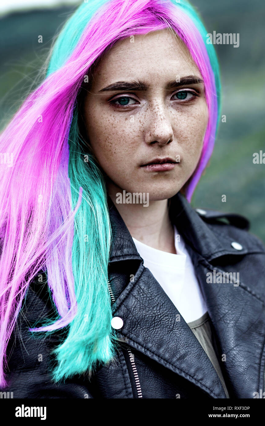 White-skinned Girl with freckles on her face, free, self-confident, with different hair color, with rainbow-colored hair looking into the camera right Stock Photo
