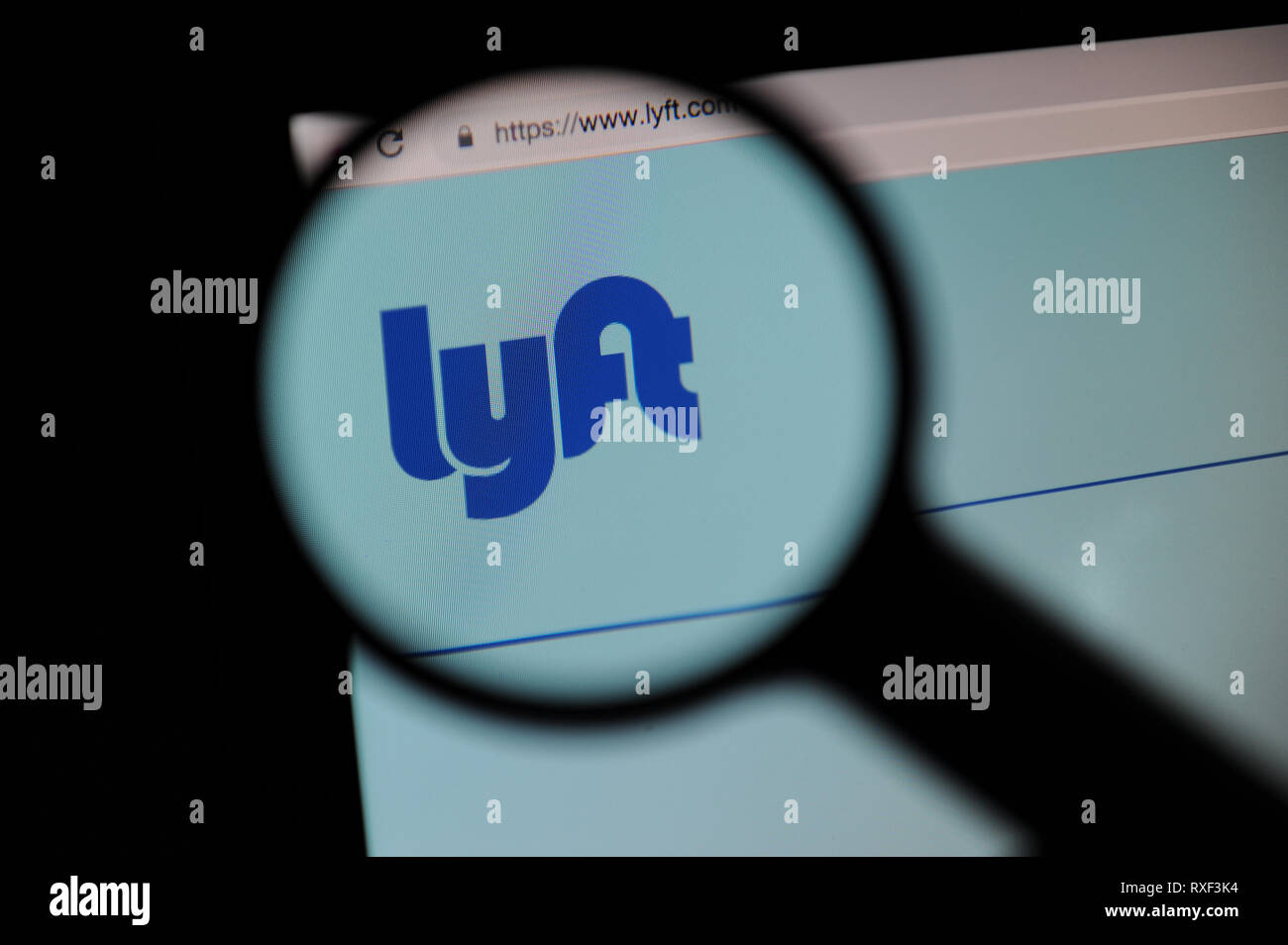 Lyft website seen through a magnifying glass, Lyft is a ride sharing company based in the US. Stock Photo
