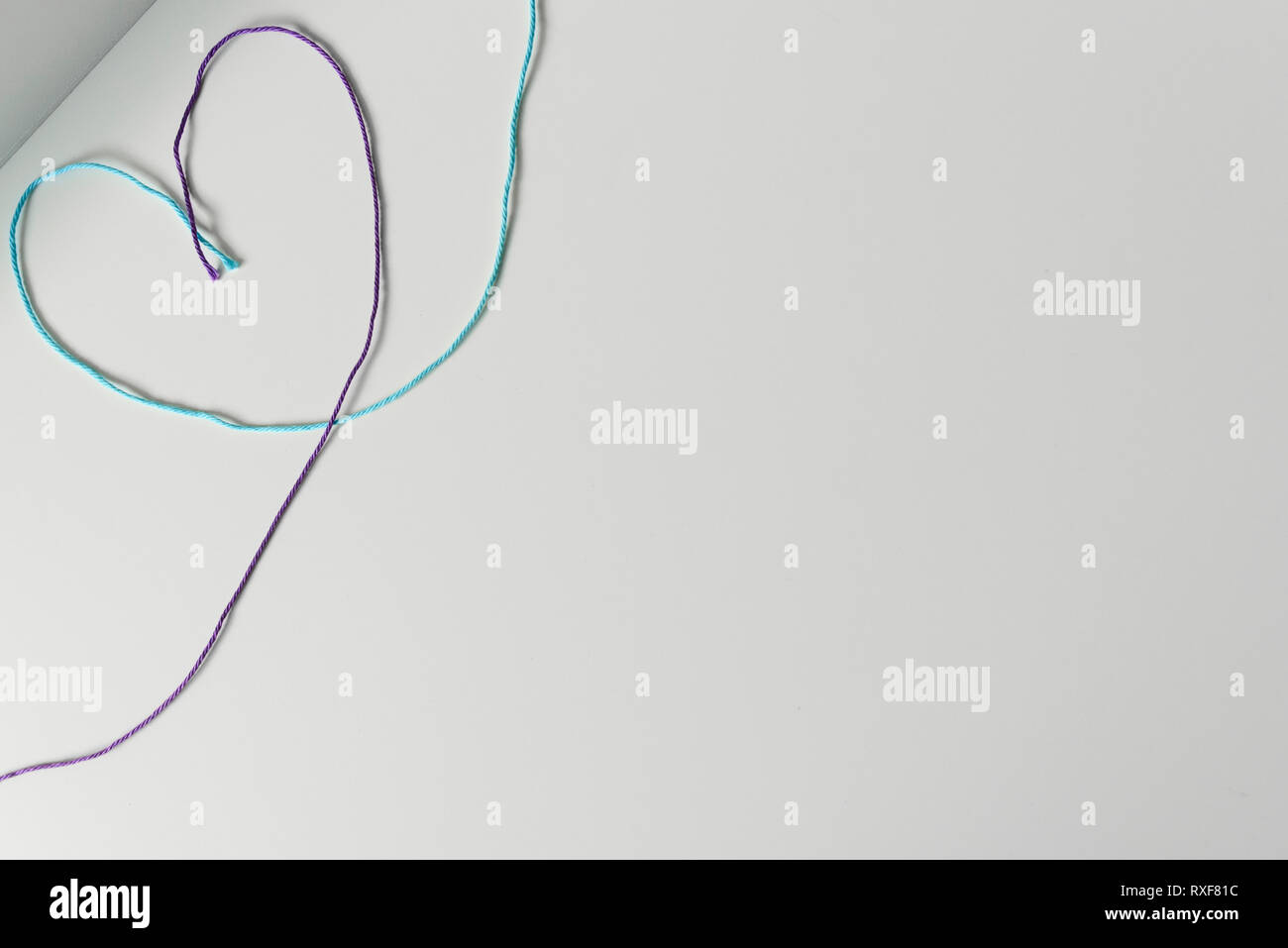 Heart symbol designed from yarn wools threads on white background with copy space. Stock Photo