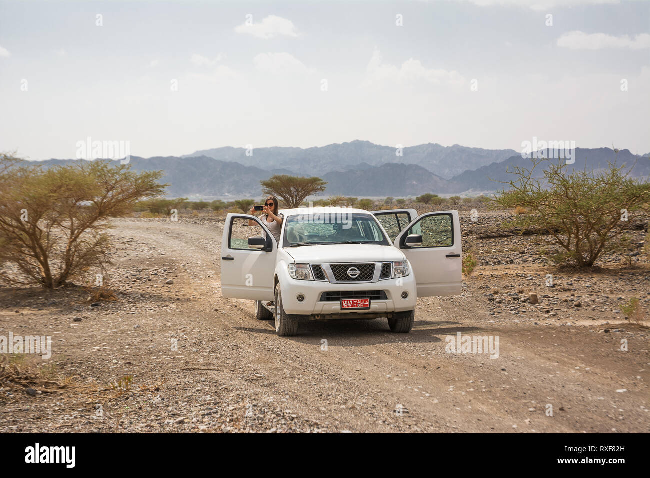 Nizwa, Oman - November 2, 1028: Off-road vehicle and tourists on the Jebel Shams mountains (Oman) Stock Photo