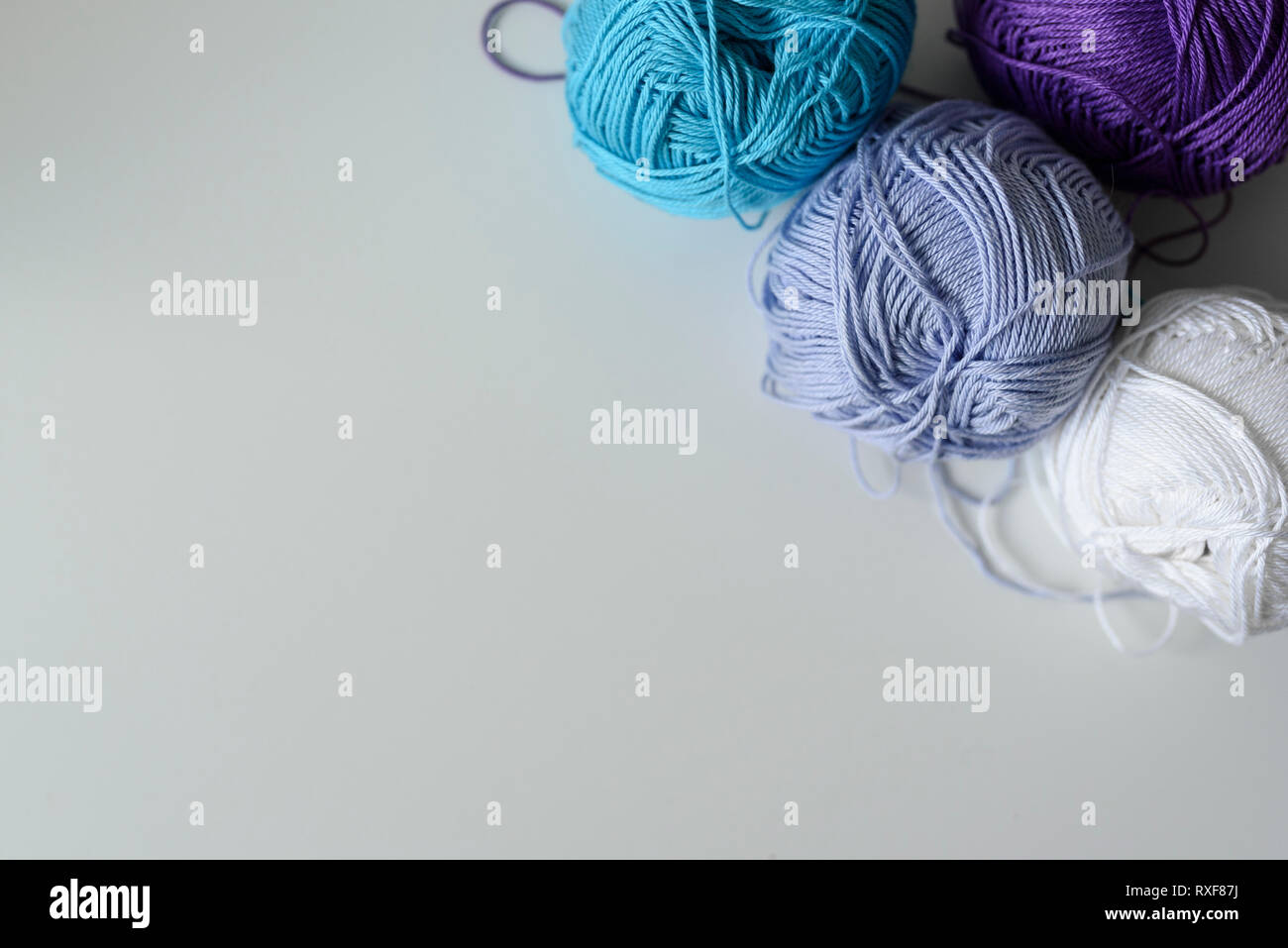 Creative decoration of colorful knitting wools for handmade on white table with copy space. Stock Photo