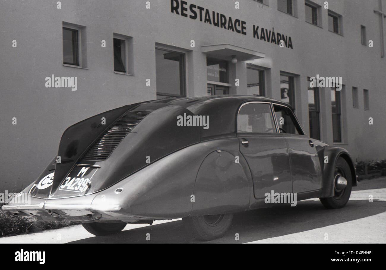 1930s, historical, a Tatra 77, a luxury four-door rear-engined motor car with a tailfin parked outside Restaurant Kavarna, Sudentenland, Czechoslovakia. Produced by the Tatra motor company in Koprivnice, Moravia, who began making cars in 1897, this futuristic car was the world's first production aerodynamic car and its streamlined design was revolutionary for the time. Stock Photo