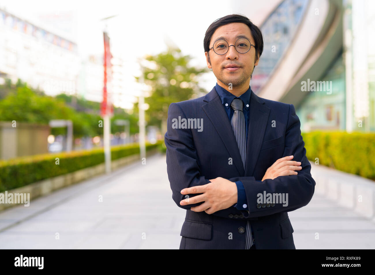 Asian businessman with arms crossed in the city outdoors Stock Photo ...