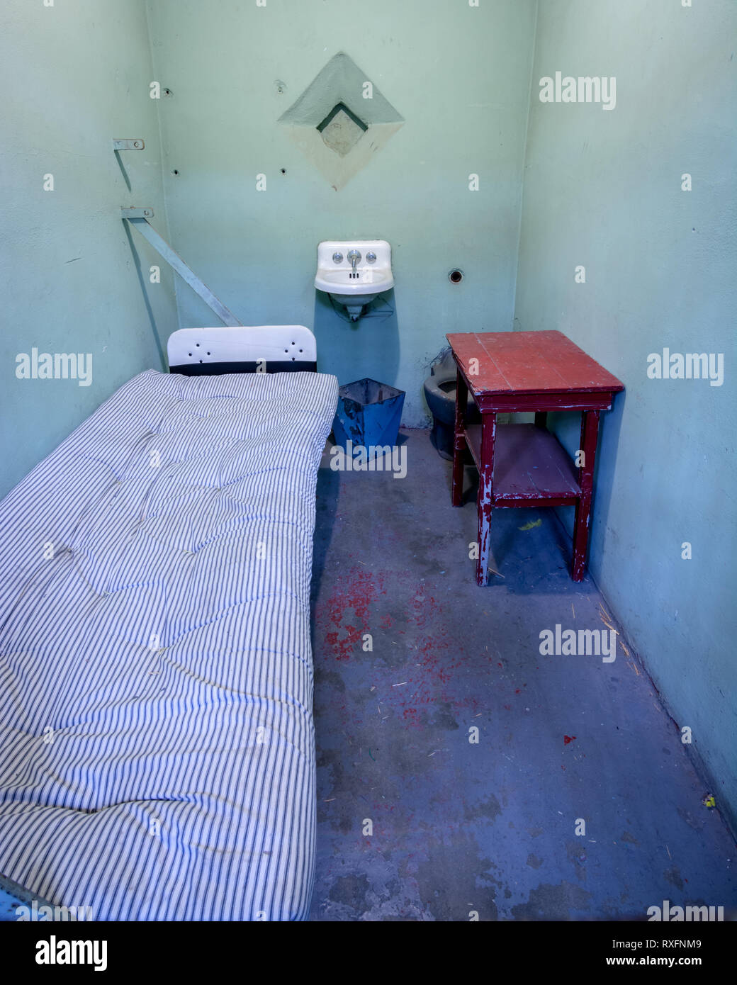 Cement jail cell closeup with a bed and mattress Stock Photo Alamy