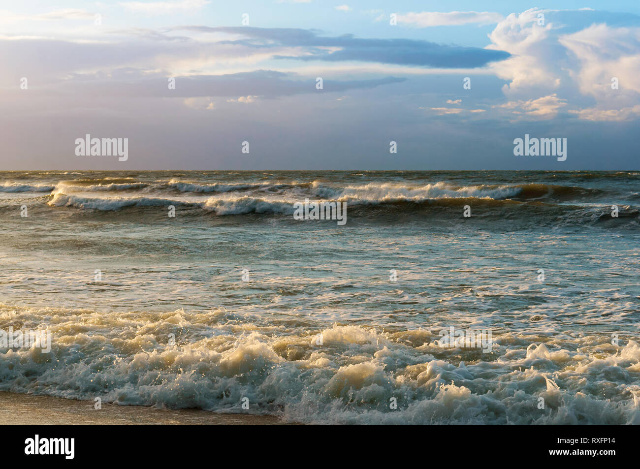 Sunset over the sea. Reflection of sunlight in the sea waves. Red sky in the rays of the sunset. Stock Photo