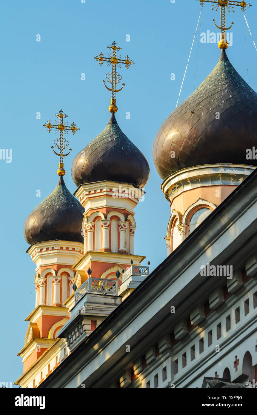 Three Copper Domes with Gilded Crosses of the Christian Church Against the Blue Sky. Stock Photo