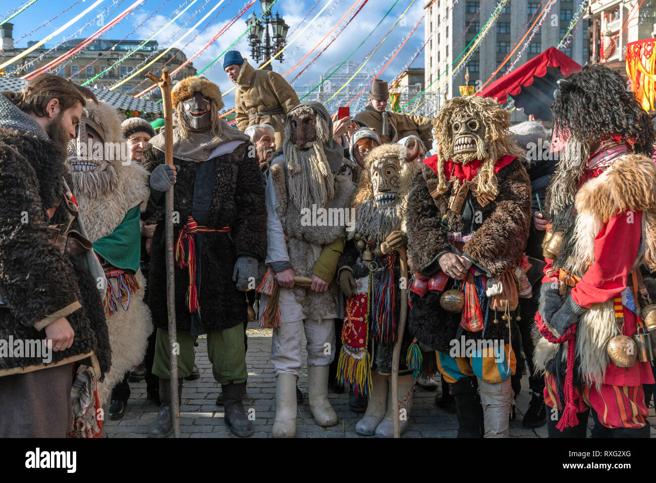 Moscow, Russia - March 9. 2019. Masked men during celebration of Shrovetide on Manezh Square Stock Photo