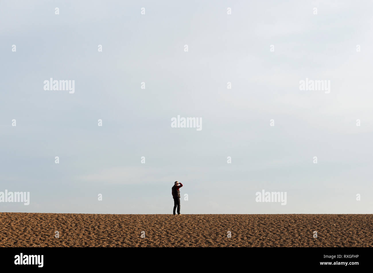 Man on a beach looking out to sea Stock Photo - Alamy