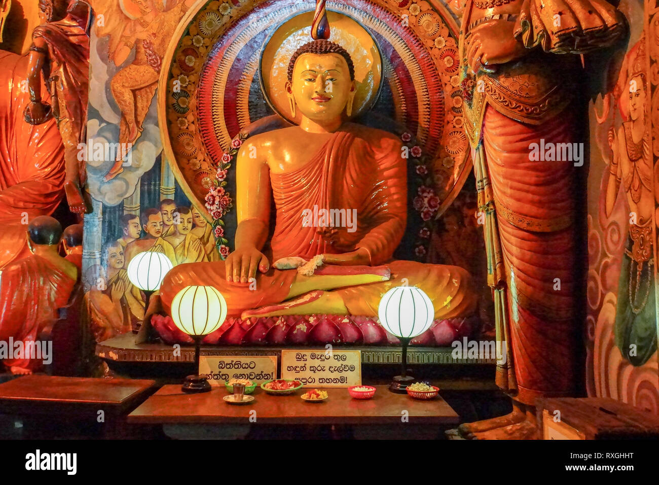 Sitting Buddha statue with offerings at Gangaramaya Temple, Colombo, Sri Lanka, Asia Stock Photo