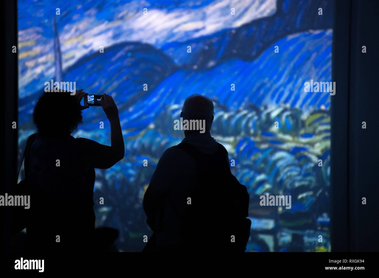 Visitors are seen taking photos of the images during the exhibition