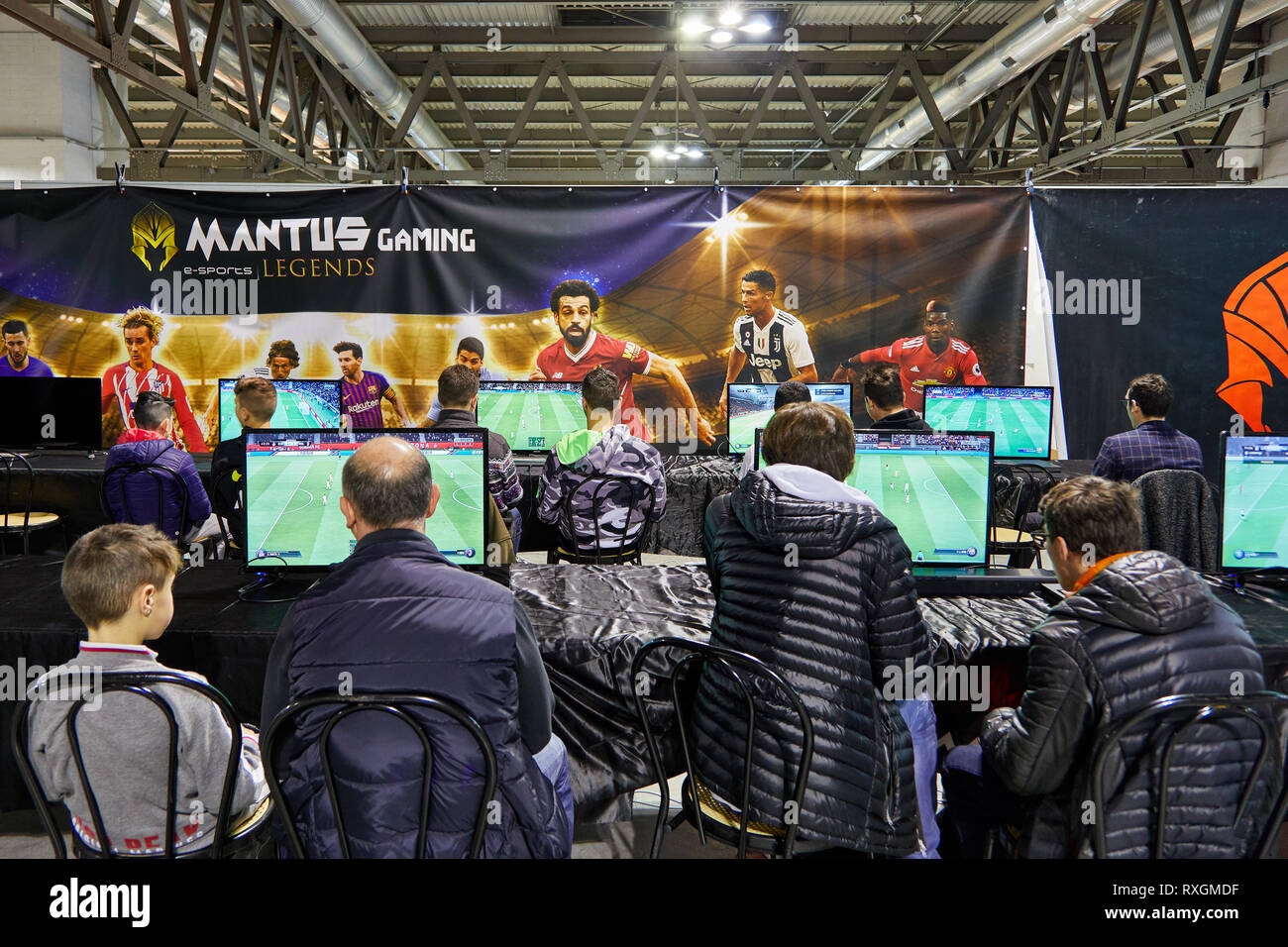 Milan, Italy - March 8 2019 Cartoomics Comic Con Visitors play FIFA 19 EA Sports game at Mantus Gaming stand Stock Photo