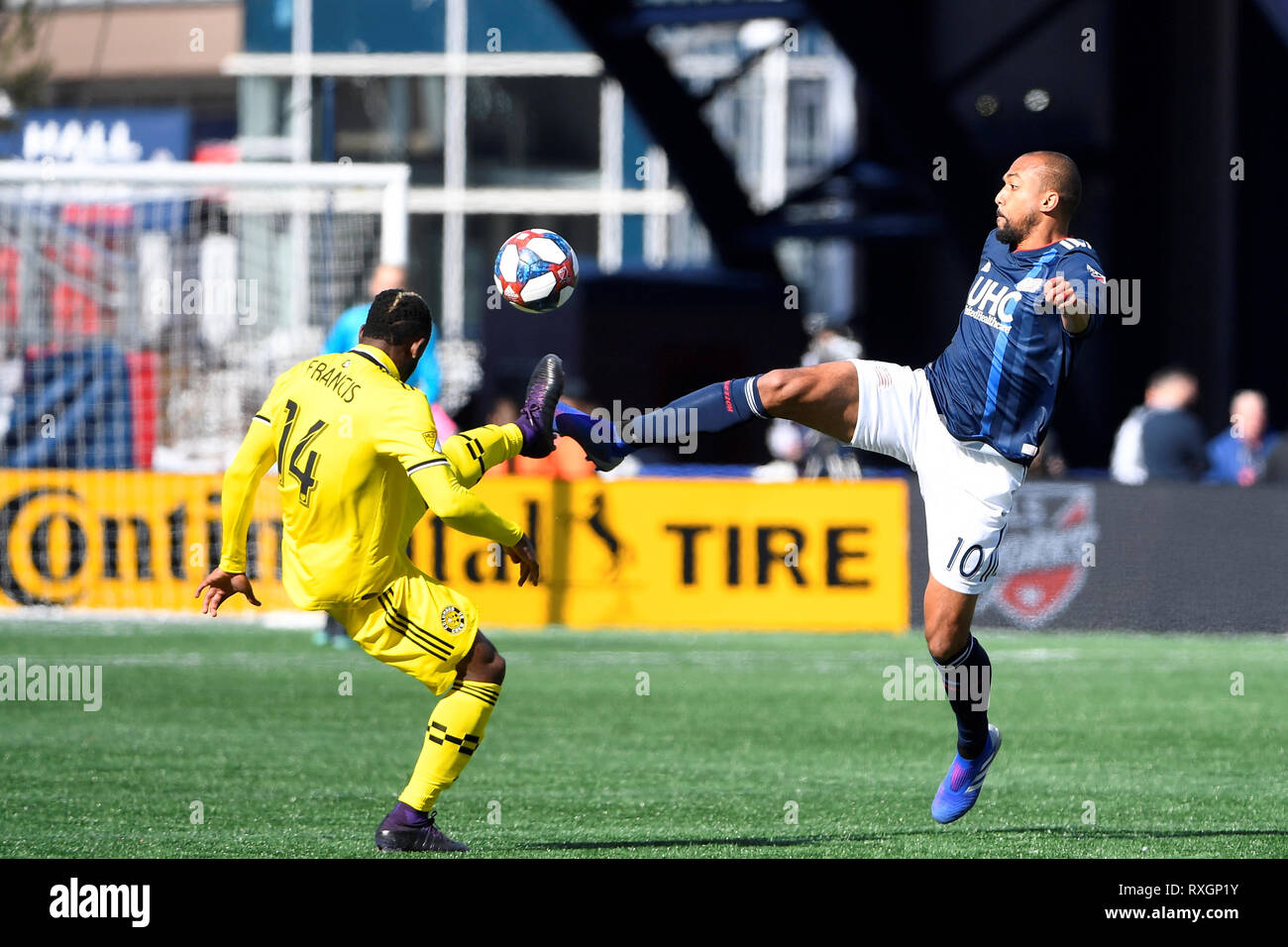 Foxborough Massachusetts, USA. 9th Mar, 2019. Columbus Crew defender Waylon Francis (14) and New England Revolution forward Teal Bunbury (10) battle for the ball on the pitch during the MLS game between Columbus Crew and the New England Revolution held at Gillette Stadium in Foxborough Massachusetts. Columbus defeats New England 2-0. Eric Canha/CSM/Alamy Live News Stock Photo