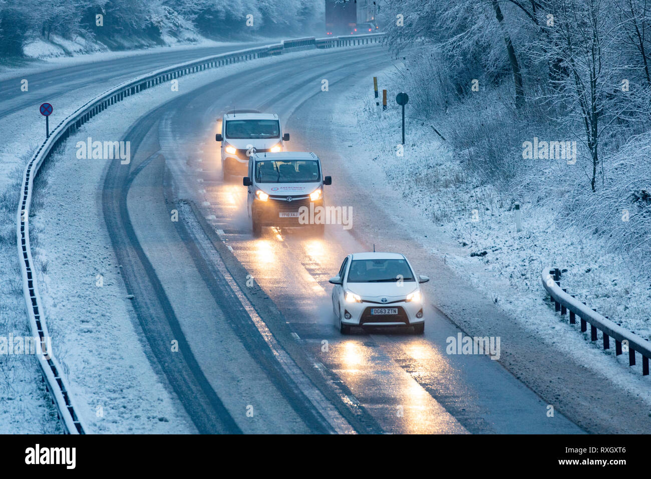 Flintshire, North Wales, UK 10th March 2019. UK Weather: March snowfall as overnight snowfall has left some parts of the UK under a blanket of snow. Flintshire, North Wales hit snowfall with a yellow Met Office warning in place for the area as these motorists discovered along the A55 near Brynford Stock Photo