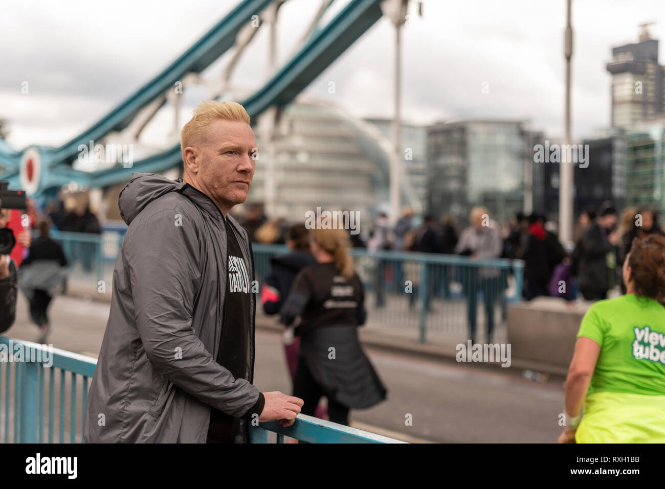 Athlete Iwan Thomas watching the runners in the Vitality Big Half half marathon crossing Tower Bridge, London, UK. Stock Photo
