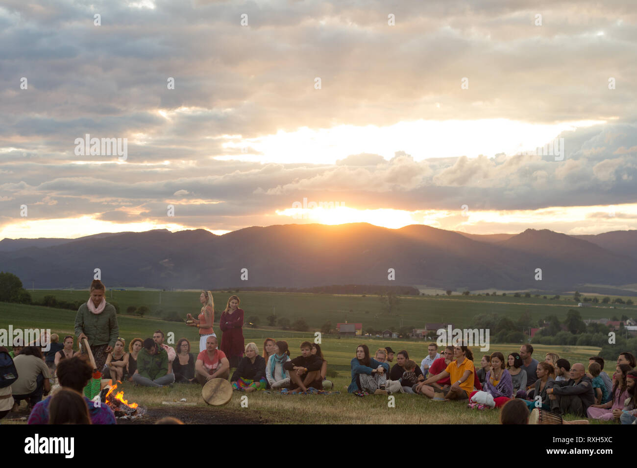 Drienok, Slovakia - June 2017: group of people sitting around bonfire enjoying sunset in Drienok, Slovakia Stock Photo