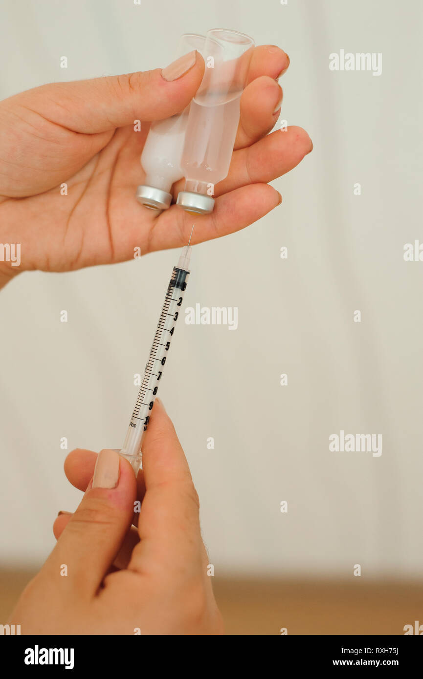 Syringe, medical injection in hand, palm or fingers. Medicine plastic