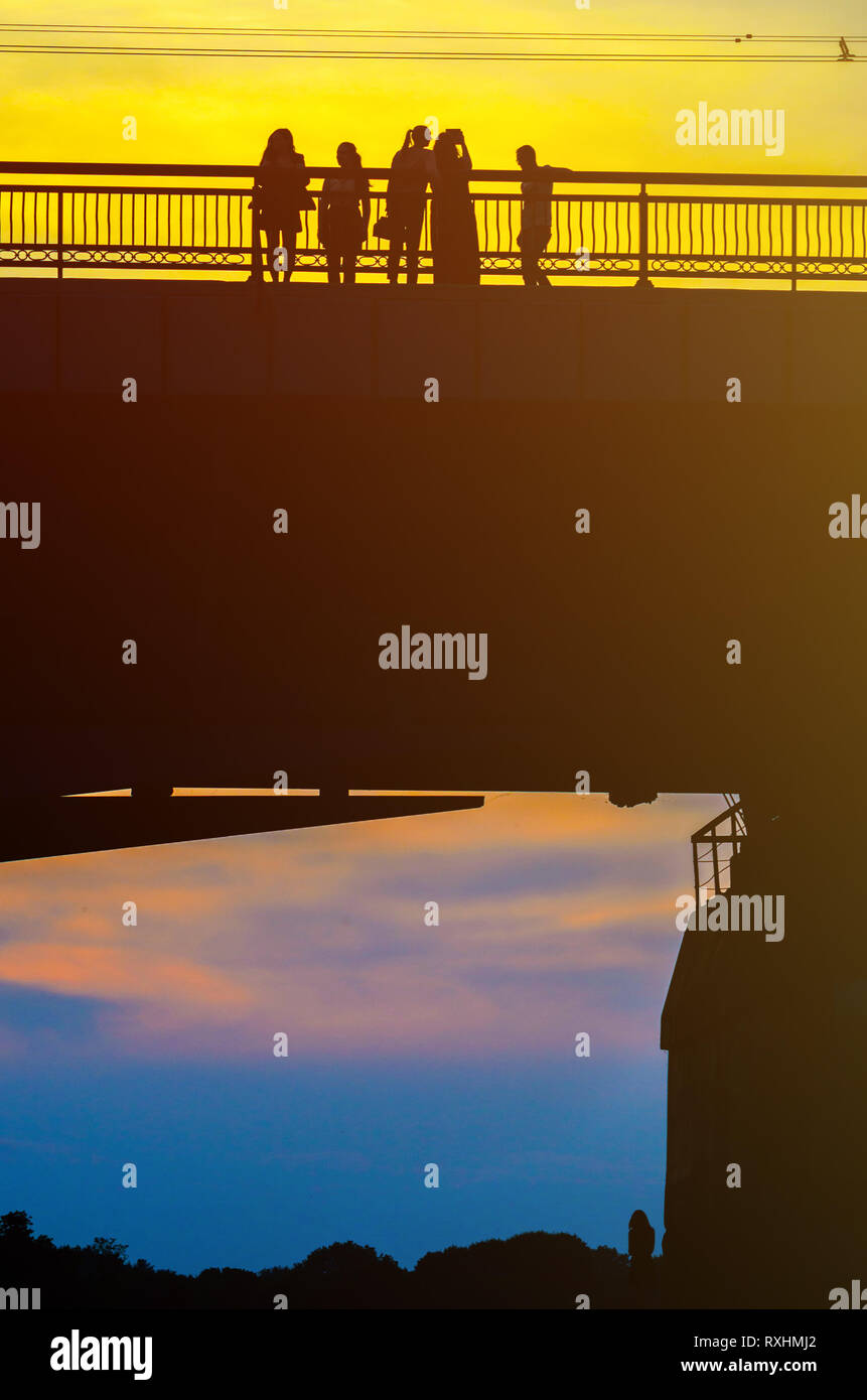 Silhouettes a Group of People on the High Bridge on a Background of ...