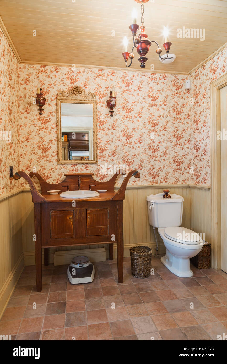 Antique Wooden Vanity And White Porcelain Toilet In Guest Washroom