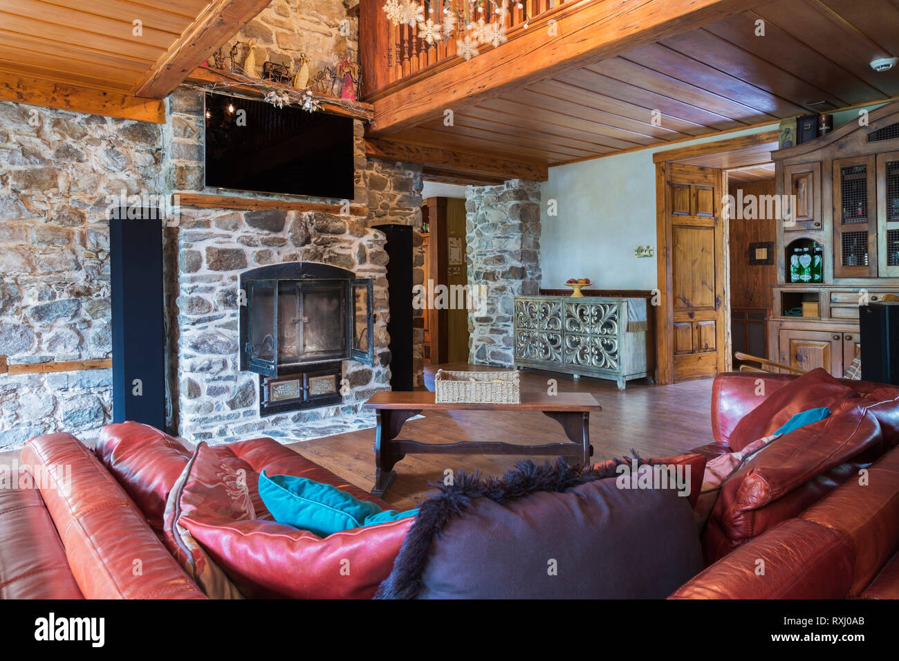 Reddish Burgundy Leather Sofas With Wooden Bench Style Coffee Table In Living Room With Natural Stone