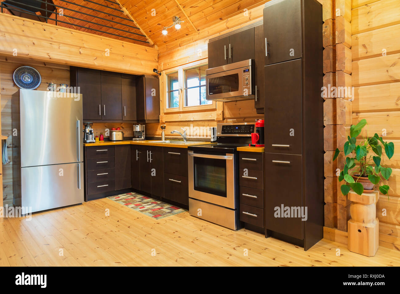 Natural Wood Countertops And Brown Cabinets With Microwave Oven
