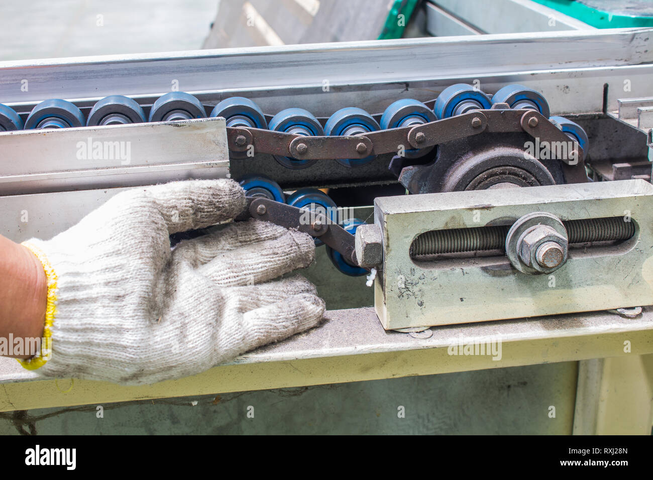 The hand of technician checking strength and tension of conveyor belt for maintenance Stock