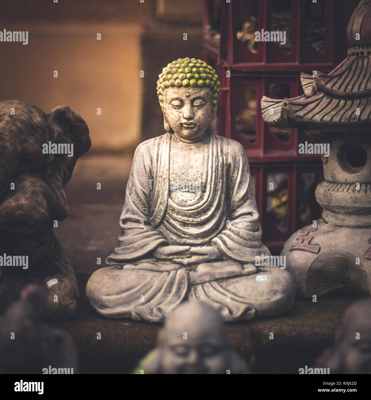 A small little Buddha statue hidden away in a market Stock Photo