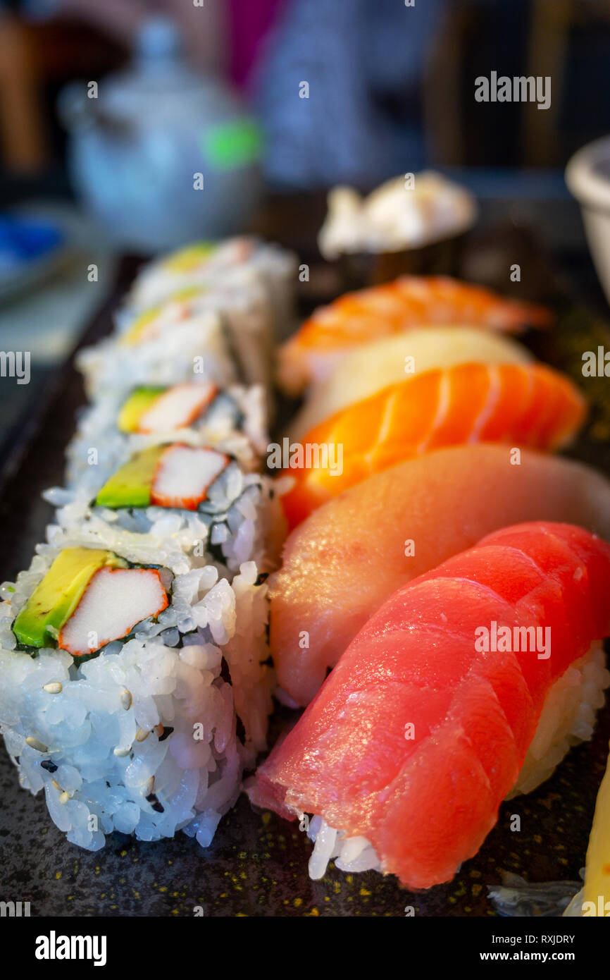 Delicious Japanese nigiri sushi bento with Tuna Toro, Tuna Ahi, Salmon Sake, Yellowtail Hamachi, Shrimp Ebi, and California roll. Vertical orientation Stock Photo