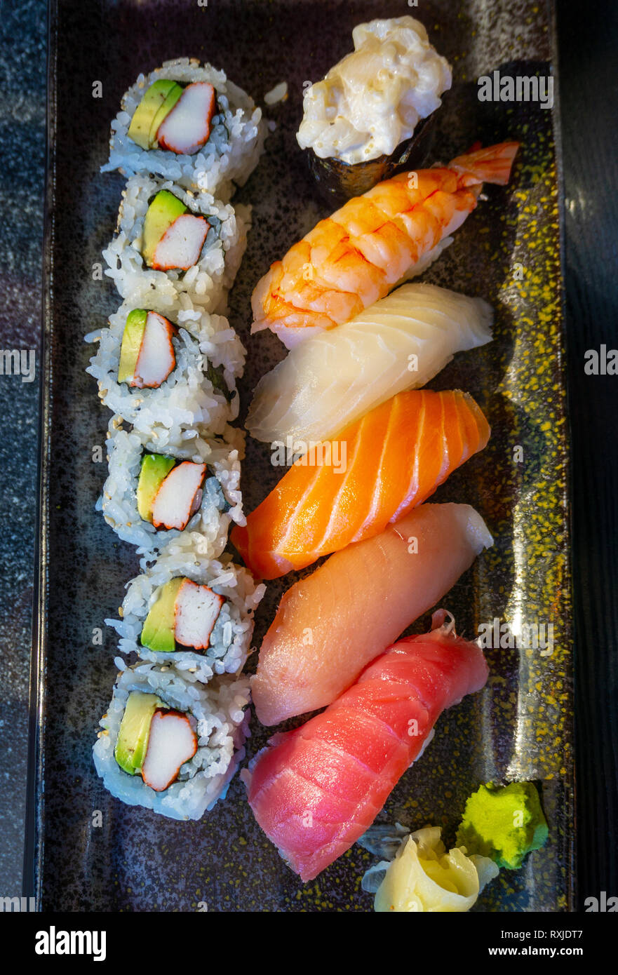 Top down view of savory Japanese nigiri sushi with Tuna Toro, Tuna Ahi, Salmon Sake, Yellowtail Hamachi, Shrimp Ebi, Scallop sushi, and California rol Stock Photo