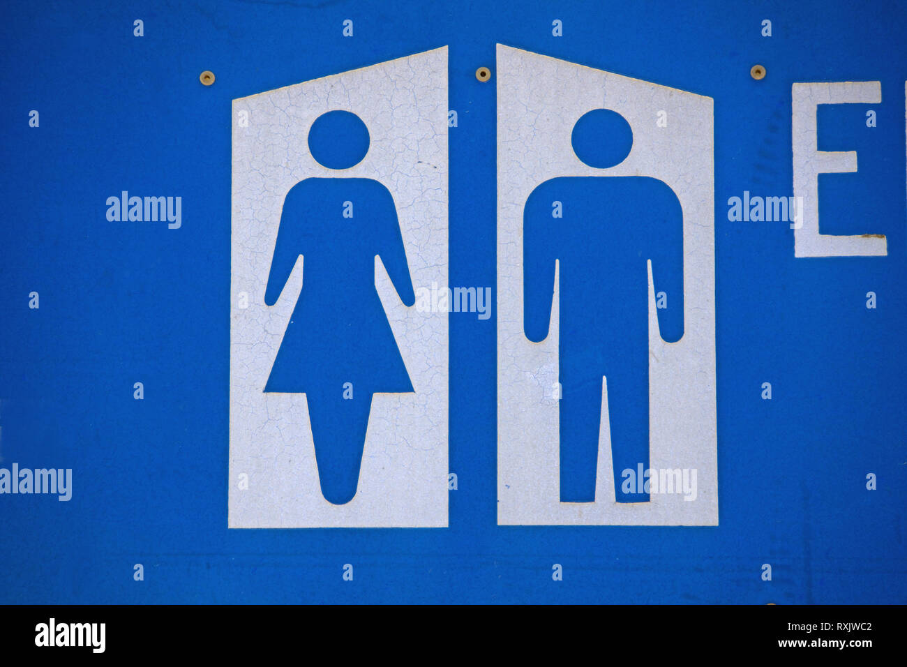 Australian toilet sign male and female symbol showing gender difference. Blue cutout gender figures with white and blue background on metal sign. Stock Photo