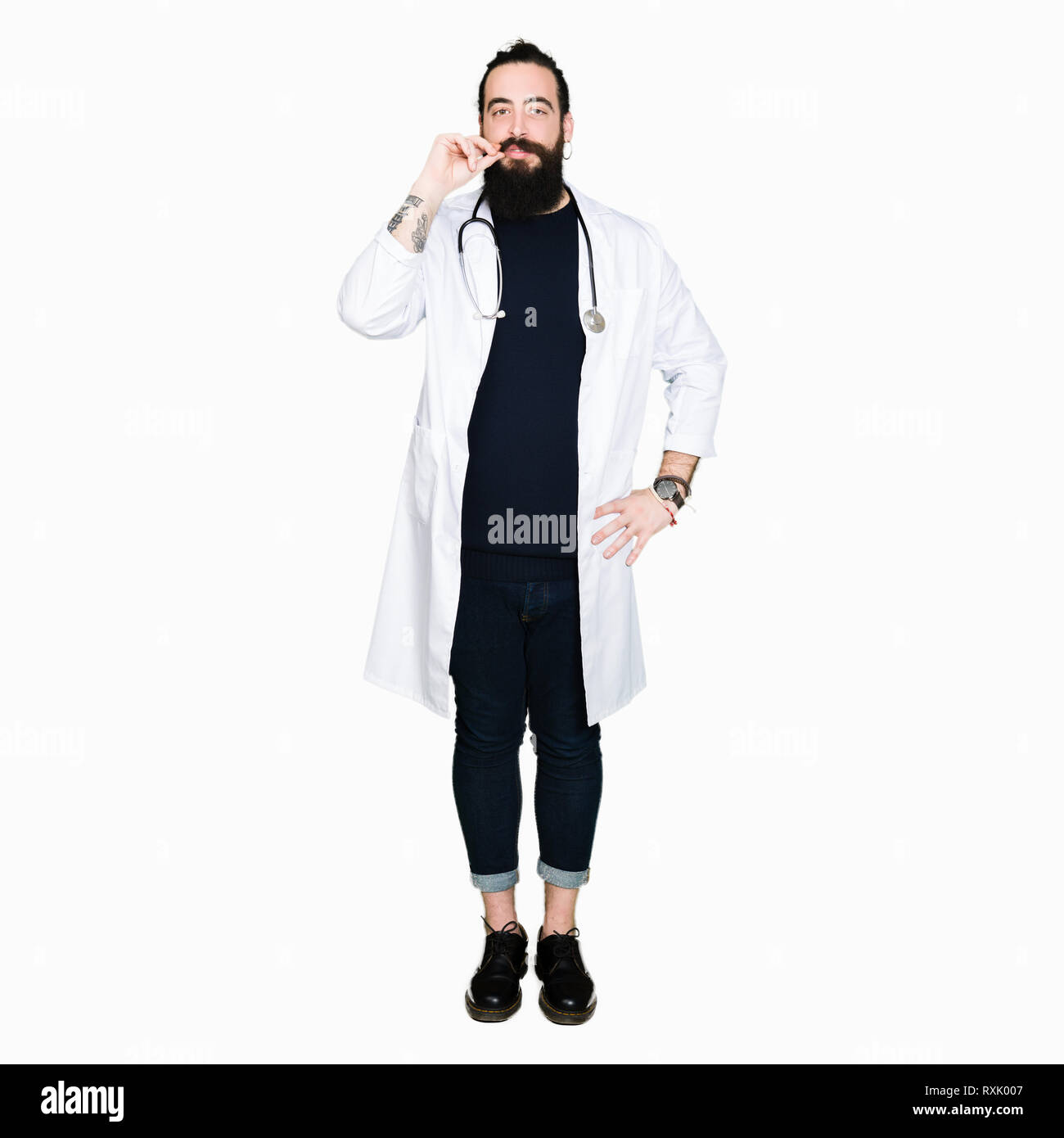 Doctor with long hair wearing medical coat and stethoscope mouth and lips shut as zip with fingers. Secret and silent, taboo talking Stock Photo
